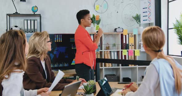 Female Business Trainer Presenting Project Strategy Showing Ideas, Financial Graph on Glass Board