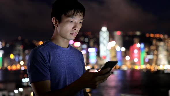 Asian man use of mobile phone at night 