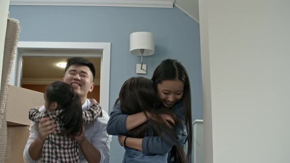 Happy Children Hugging Parents in New House