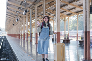 Young Asian woman in modern train station Female backpacker passenger waiting for train at train