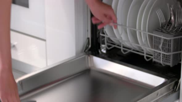Housewife Taking Out Clean Plates From Dishwasher Machine