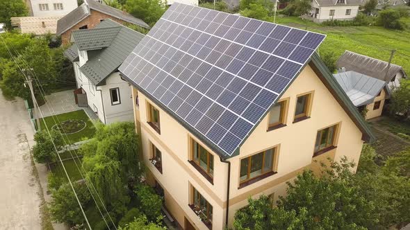 Aerial top view of new modern residential house cottage with blue shiny solar photo voltaic panels