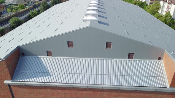 Big building insulated with grey insulation thermal panels and light domes on top of it. Aerial 4k v