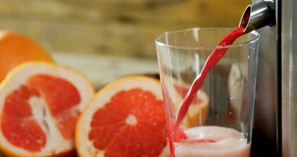 Grapefruit with juice maker on wooden table 4k