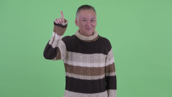 Happy Mature Japanese Man Pointing Up Ready for Winter