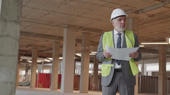 Foreman Holding Paper at Construction Site