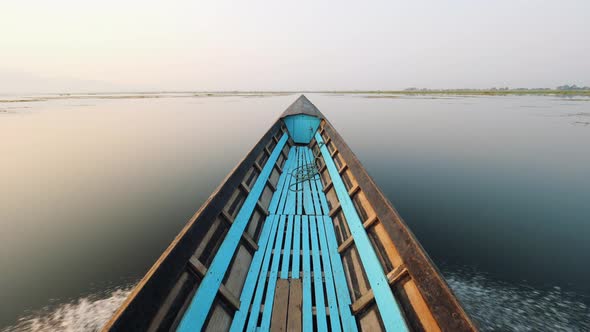 Old Blue Wooden Boat Floats on the Calm Water Surface Early Morning. Inle Lake, Myanmar. Slowmotion