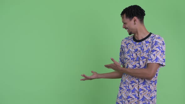 Happy Young Handsome African Man Showing To Back and Giving Thumbs Up