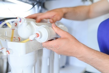 Plumber installs or change water filter. Replacement aqua filter.