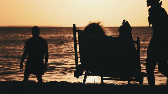 Silhouette of Woman Lying on Sun Lounger Looking at Sunset By Ocean Zanzibar