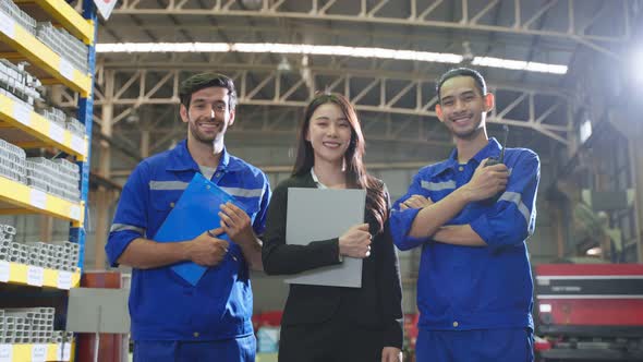 Portrait of industrial man worker and businesswoman working in factory.