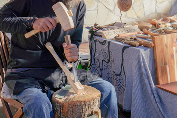 craftsman working with wood at a street market