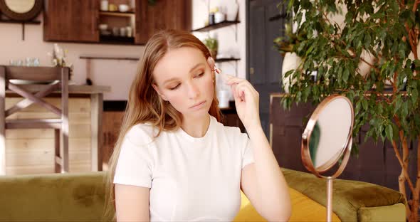 Young woman makes herself a face massage with a massage quartz roller