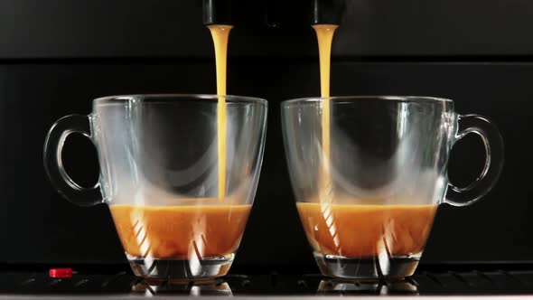 Brewed Coffee Is Poured From the Coffee Machine Into Glass Cups
