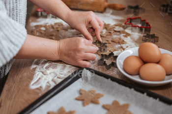 Close up of hands cutting christmas cookies with cookie cutters