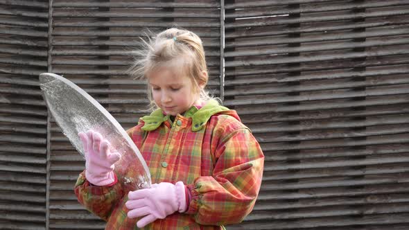 The Girl Holds An Oval Ice Floe In Her Hands And Examines It From All Sides