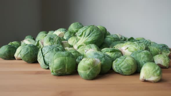Close Up Slow Motion Push In To Heap of Raw Brussels Sprouts on Wooden Tabletop