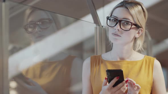 Young Blonde Businesswoman Holding Smartphone and Posing for Camera