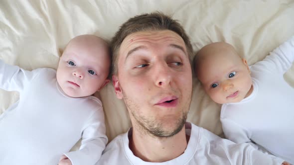 Happy Father And Two Daughters Lying On Bed