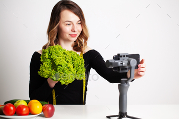 A young woman in lightroom writes a blog on weight loss and healthy eating