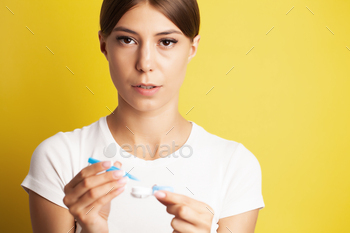 Smiling woman with contact eye lenses and container in hand
