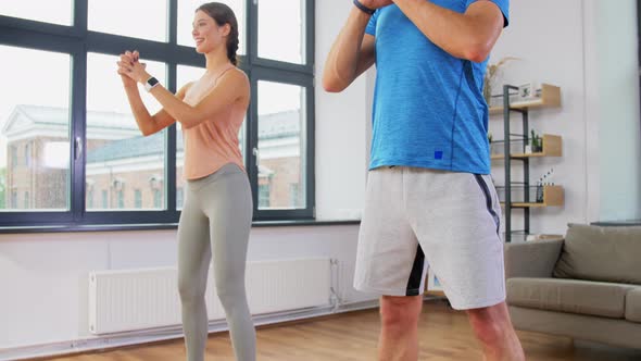 Happy Couple Exercising and Doing Squats at Home