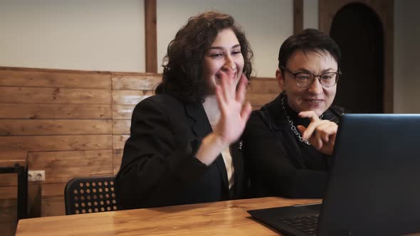 Mother and Daughter Talking Use Laptop to Talk on Video with Father Brother Friends