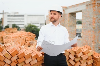 Construction concept of Engineer working at Construction Site with blue print.