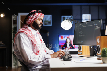 Muslim developer writes code on computer