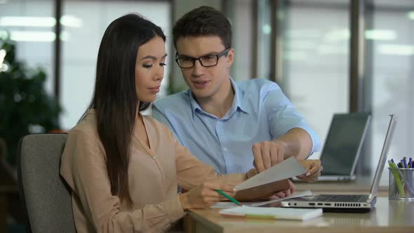 Male Assistant Showing to His Asian Lady Boss Companys Profit in Graphs, Success