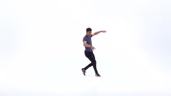 Man Is Dancing Breakdance on the White Background in Simple Grey T-shirt and Grey Jeans. Slow Motion