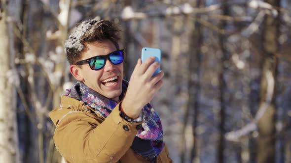 Happy Guy Throwing Snow Up in Front of Camera