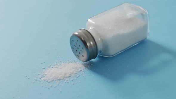Video of salt in a salt shaker on blue background