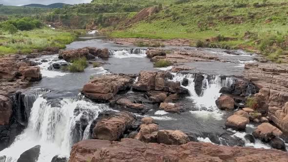 Aerial HD slow motion 50fps drone footage of the surrounding landscape and small waterfalls along th