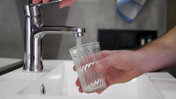 Pour Filtered Drinking Water Into A Glass. The Person Consumes Water.