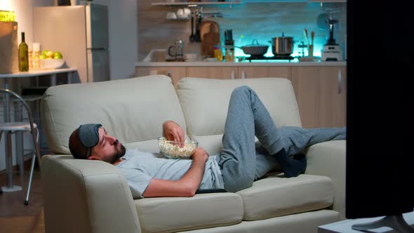 Man Lying on Sofa Falling Asleep in Fron of the TV