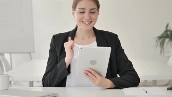 Young Businesswoman Celebrating Success on Tablet