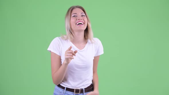 Happy Young Beautiful Blonde Woman Pointing at Camera