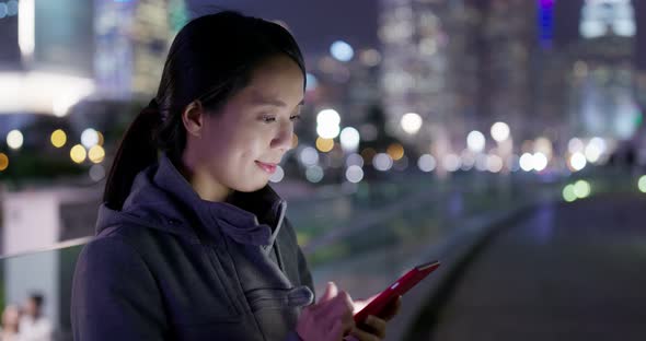 Asian woman use of mobile phone in city at night