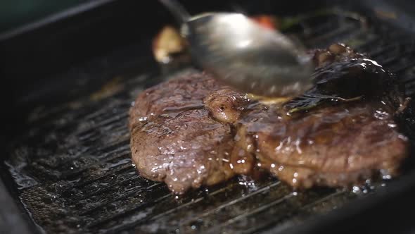 male pours  oil on steak grill pan. Cooking Fried steak in restaurant. close up