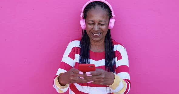 Senior african woman listening music playlist from smartphone app