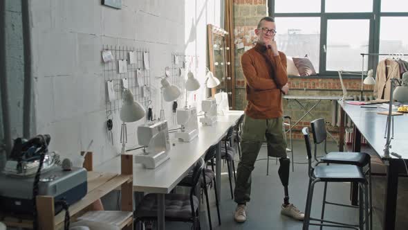 Fashion Designer with Artificial Leg Posing in Workplace