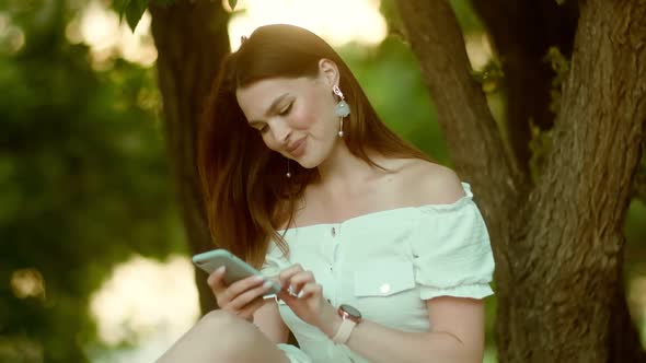 Young Woman Texting on a Mobile Phone Outdoors