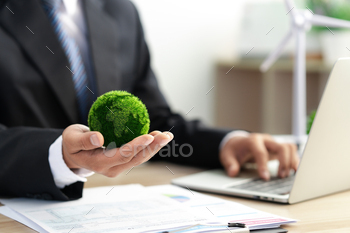 Businessman holds a green ball globe. ESG concept. Environmental, social and governance