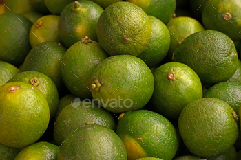 Fresh green lime fruits on market stall