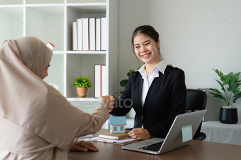 Real state agent shaking hand with Arabian Muslim customer after contract signature