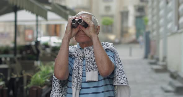 Senior Man Tourist Exploring Town, Looking in Binoculars. Travel Lviv, Ukraine