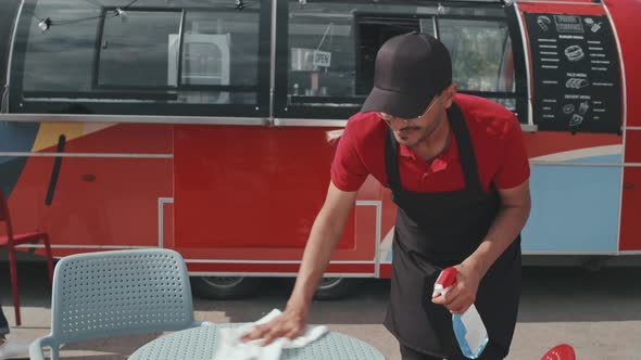 Food Truck Worker Cleaning Tables Outside