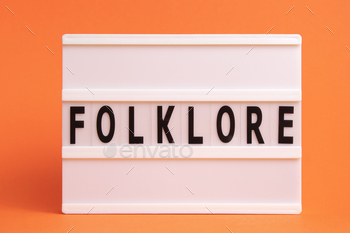 The word folklore on lightbox isolated orange background. Literary Genres