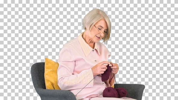 Mature grandmother sitting and knitting, Alpha Channel